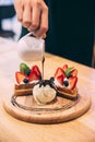 Waffles topping with slices of strawberry and blackberry served with Ã Â¹â¡hand pouring chocolate on a scoop of ice cream Royalty Free Stock Photo